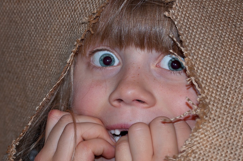 La imagen muestra una niña mostrando la emoción de susto