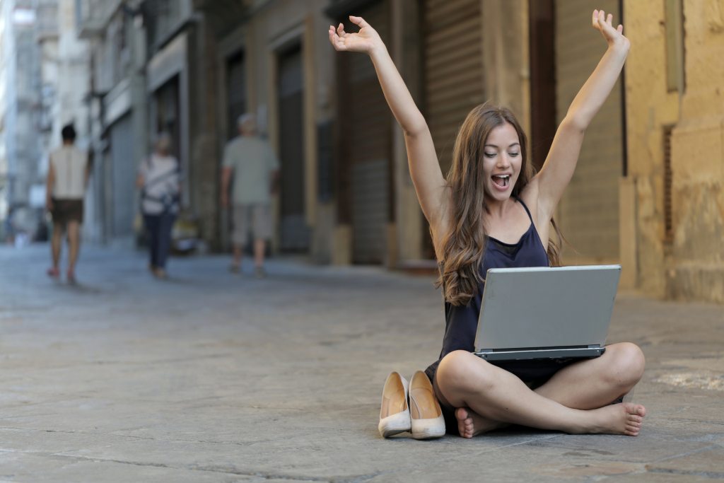 La imagen muestra a una chica alzando los brazos de alegría.