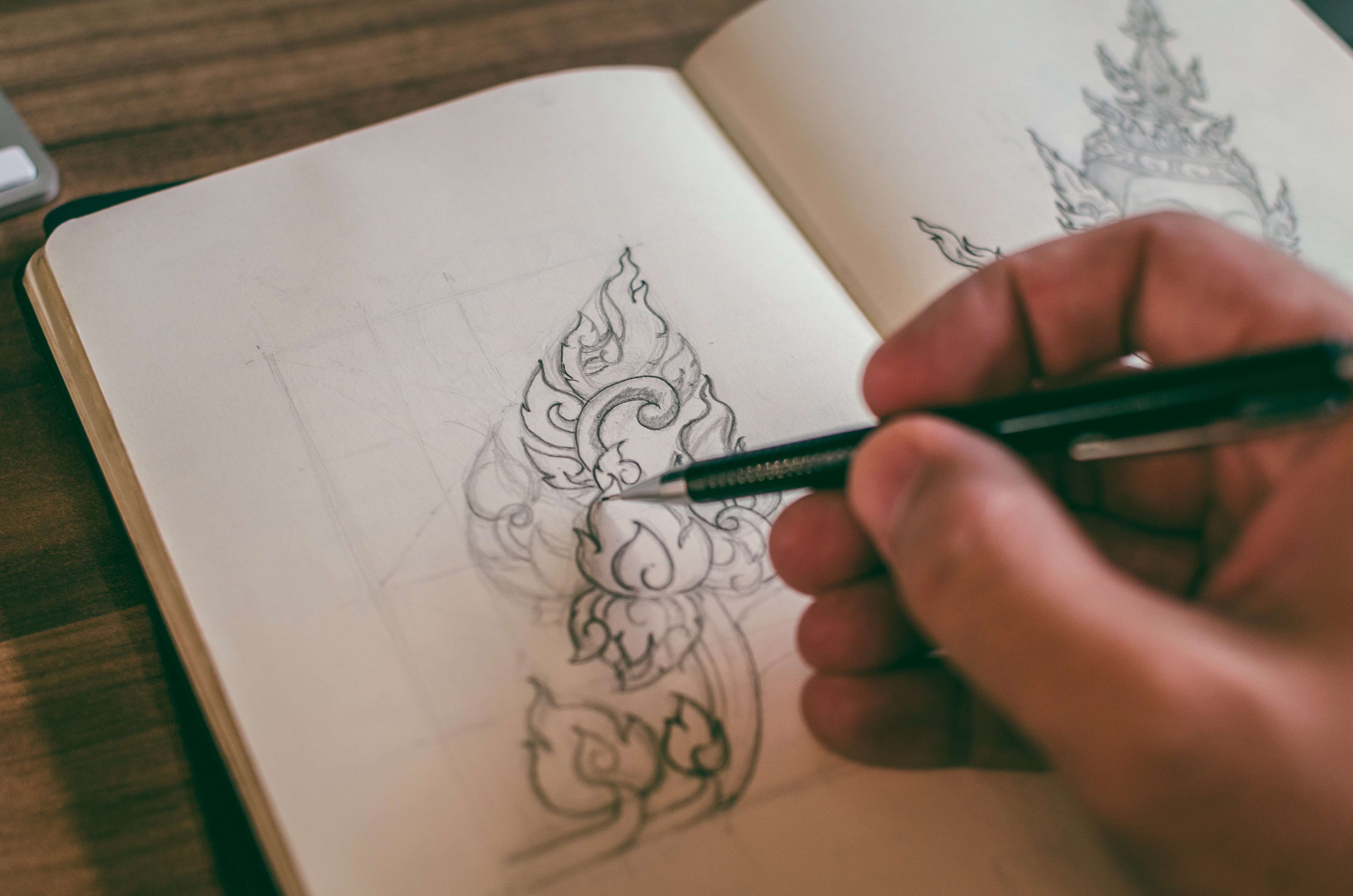 La imagen muestra una mano dibujando unas flores con un lápiz.