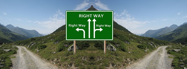 La imagen muestra un cartel de carretera de montaña con diferentes flechas para continuar el camino.