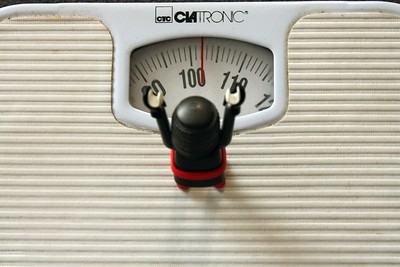 La imagen muestra un muñeco sobre una báscula que señala más de 100 kilos.