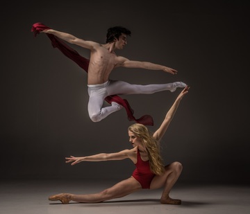 La imagen muestra una pareja de ballet saltando y estirando.