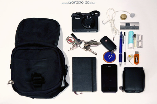 La imagen muestra una mochila, unas llaves, agenda movil, llaves delcoce, boligrafo, pastillas, pendrive y una cámara de fotos.