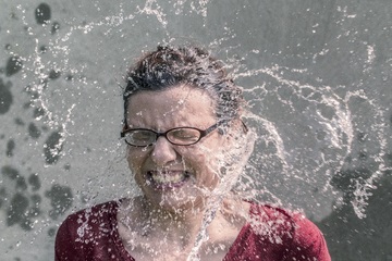 La imagen muestra a una persona que le echan agua a la cara de imprevisto.