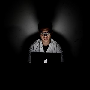 Man sitting in front of computer in dark room