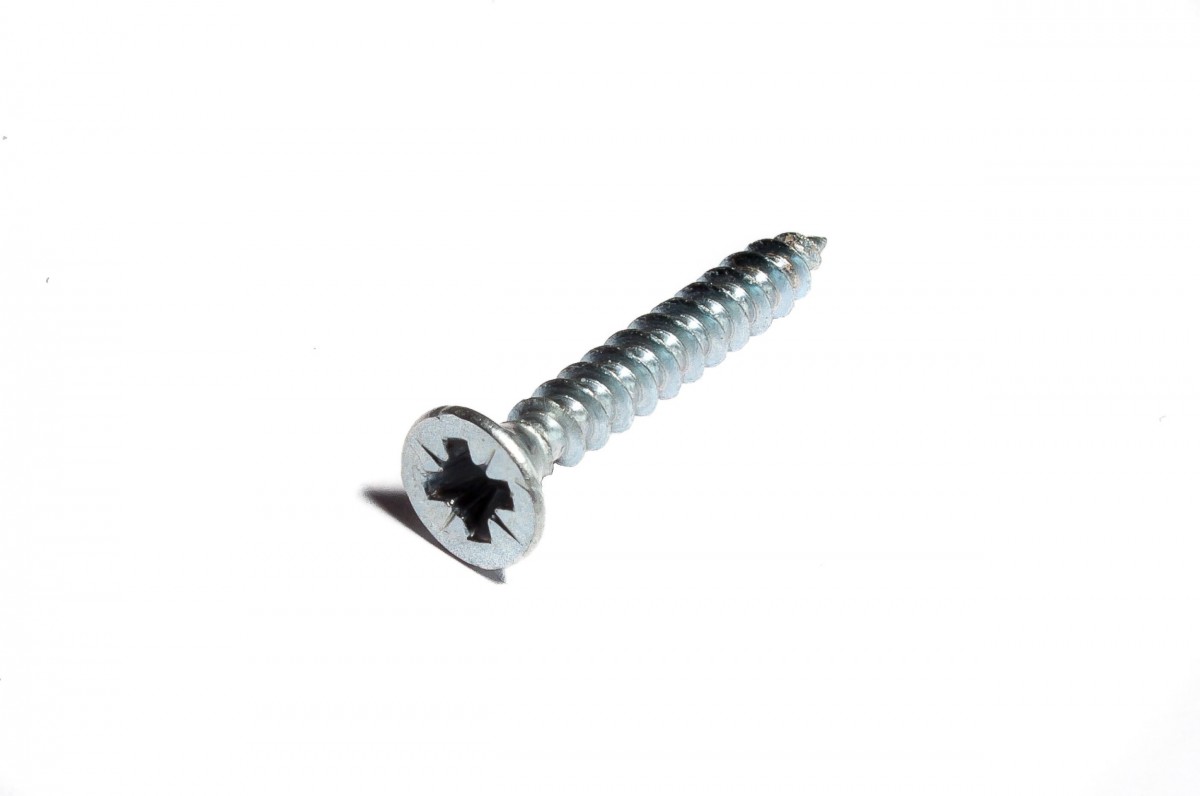 La imagen muestra un tornillo plateado corto