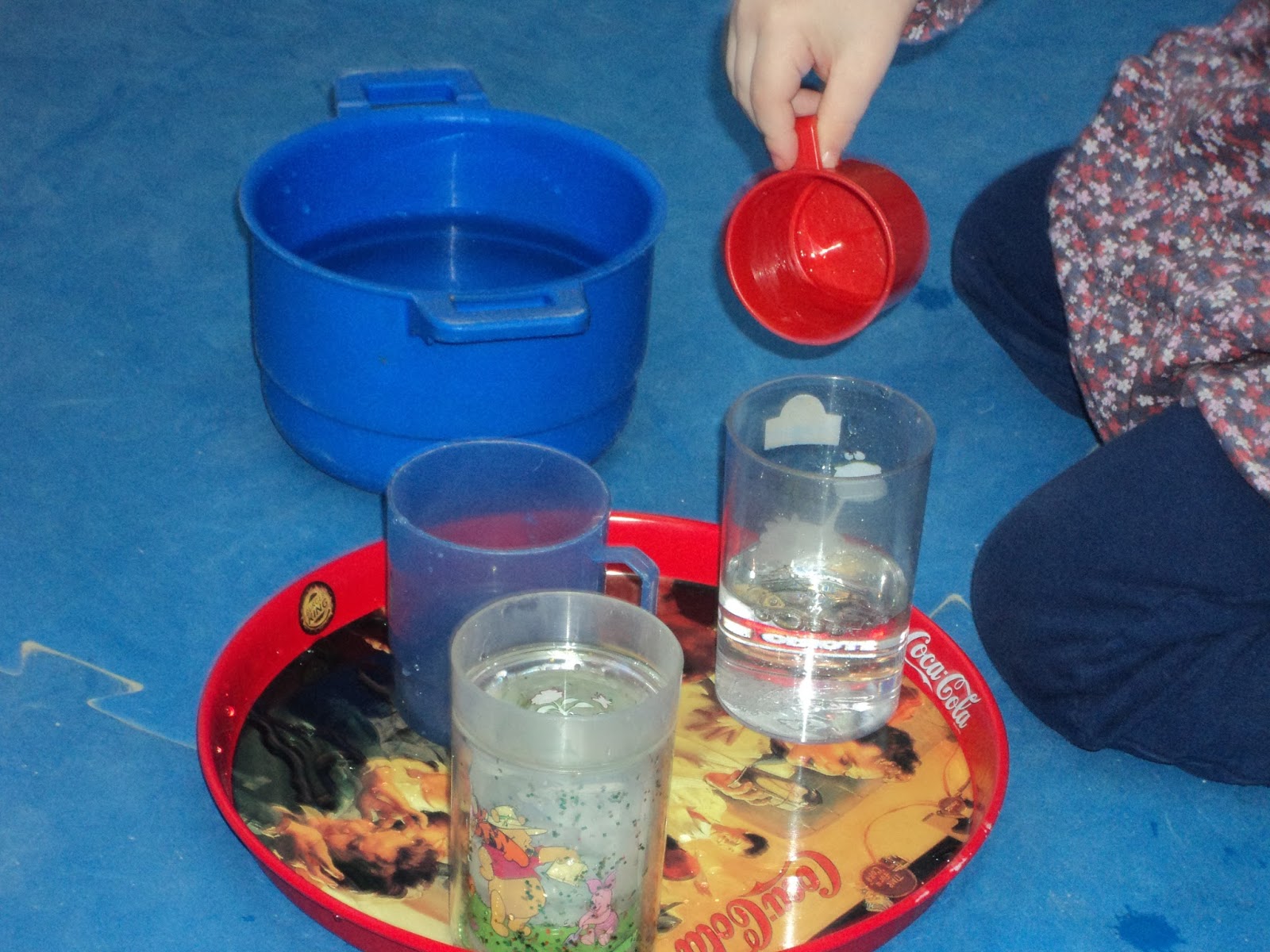 La imagen muestra como se llenan vasos con el el agua de otros recipientes