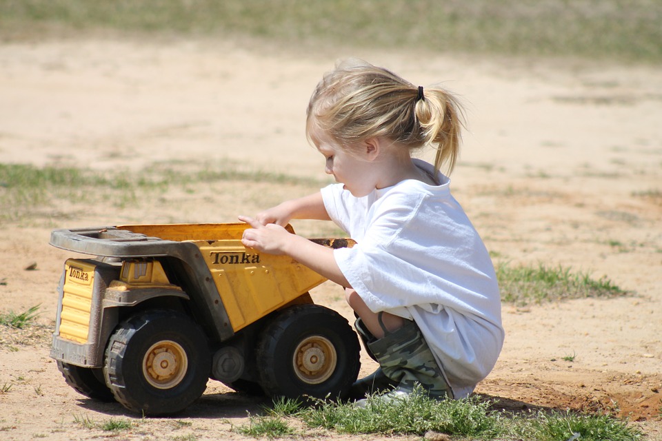 Niña jugando con un camión