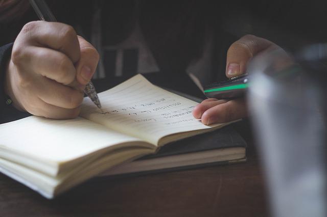 Tomando notas con bolígrafo en un cuaderno