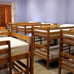 En la imagen se puede ver una habitación con ocho literas de madera.