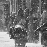 En la imagen se ve gente en la calle mientras llueve mucho.