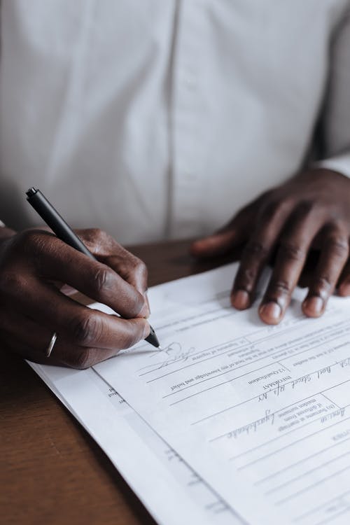 a imagen muestra a una persona firmando un contrato.