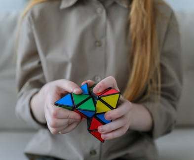 La imagen muestra a una niña resolviendo un cubo de Rubik