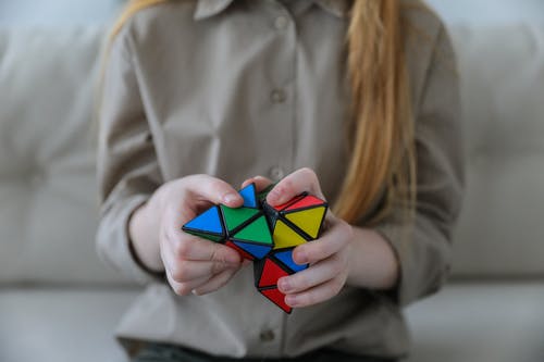 La imagen muestra una persona resolviendo el cubo de Rubik