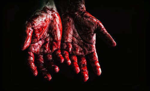 LLa imagen muestra dos manos abiertas manchadas de sangre.