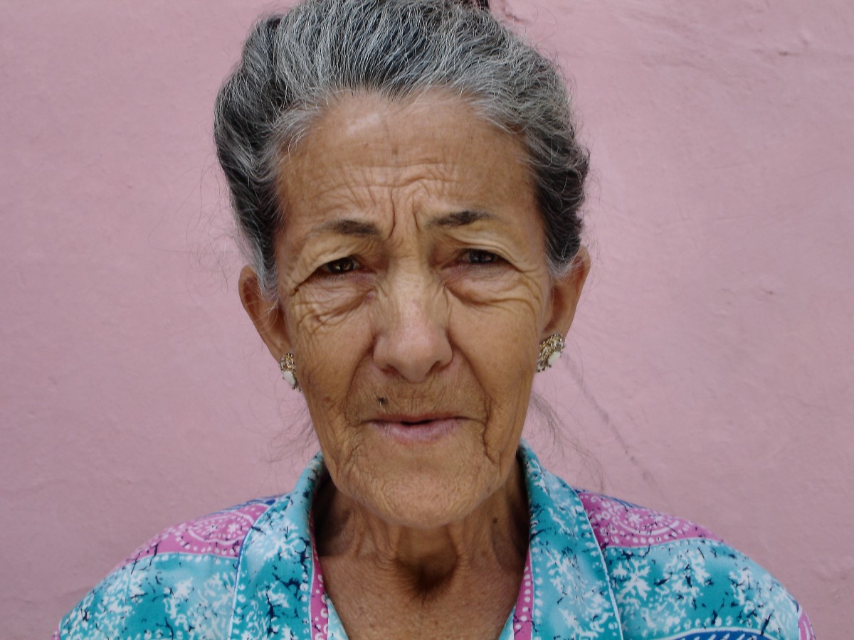 La imagen muestra a una mujer mayor mirando de frente.
