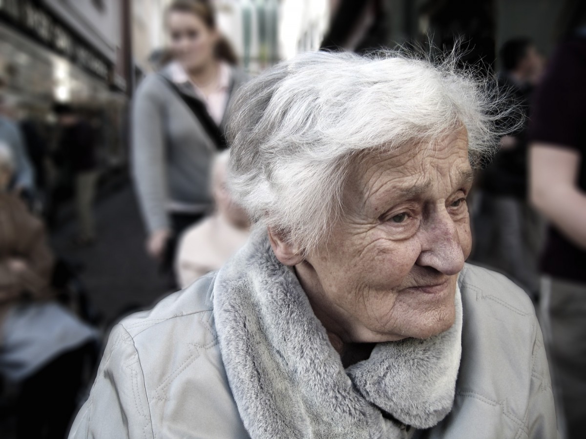 La imagen muestra a una señora mayor con el pelo despeinado, mirando hacia un lado.