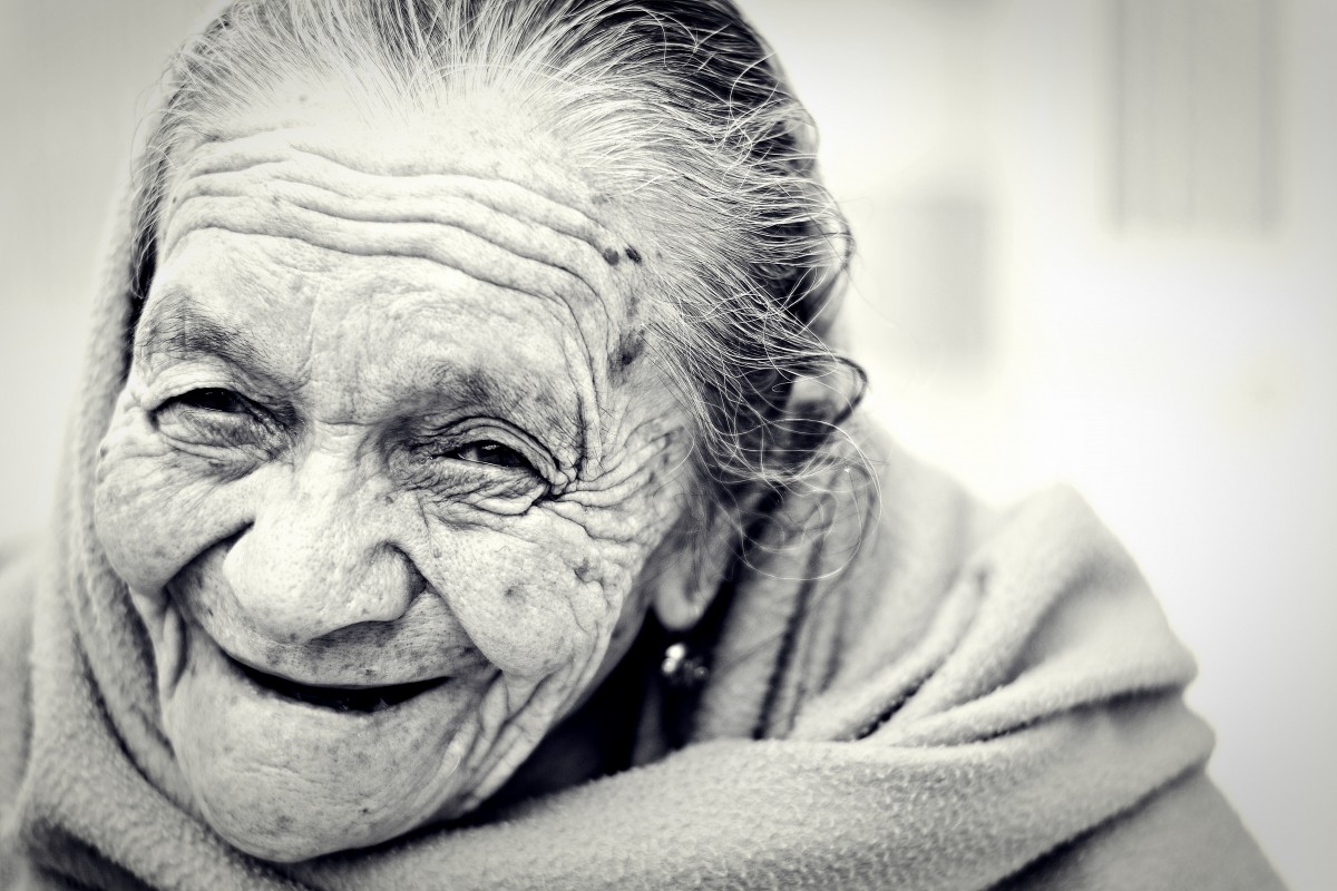 La imagen muestra a una mujer mayor muy sonriente.