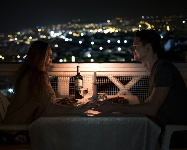 La imagen muestra a una pareja cenando en la terraza de un restaurante.