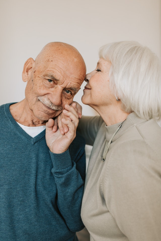 La imagen muestra una pareja de personas mayores en actitud cariñosa. 