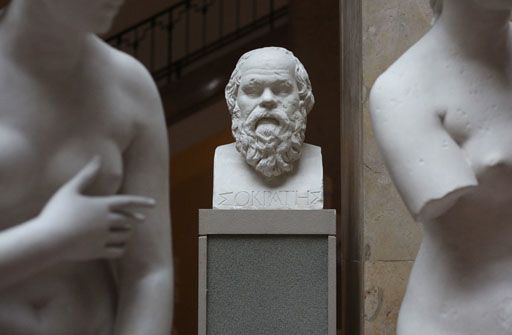 Un busto de Sócrates entre los torsos desnudos de dos diosas