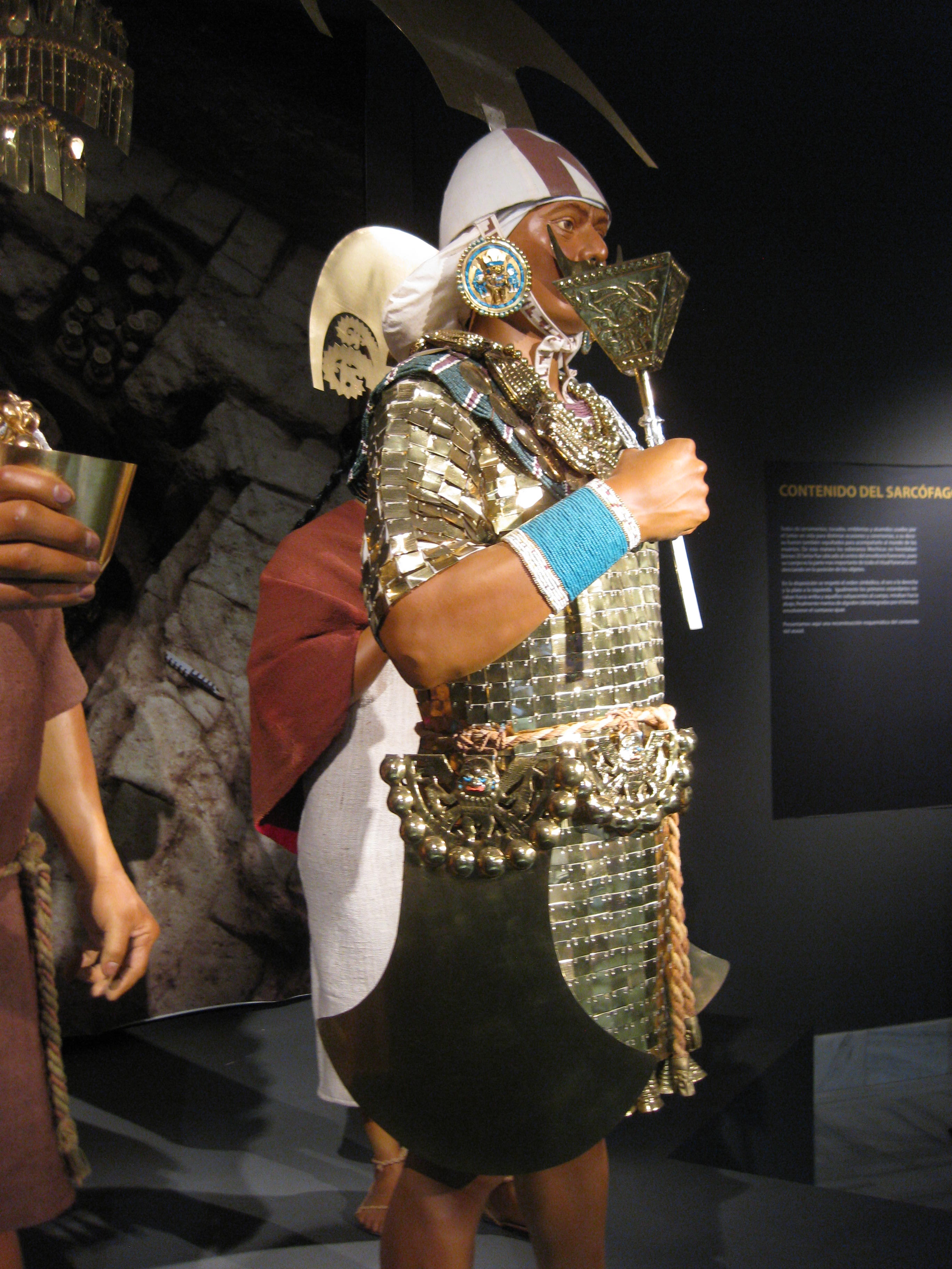 Imagen de un maniquí que recrea un traje típico tribal. Aparece el maniquí desde la cabeza a las rodillas.
