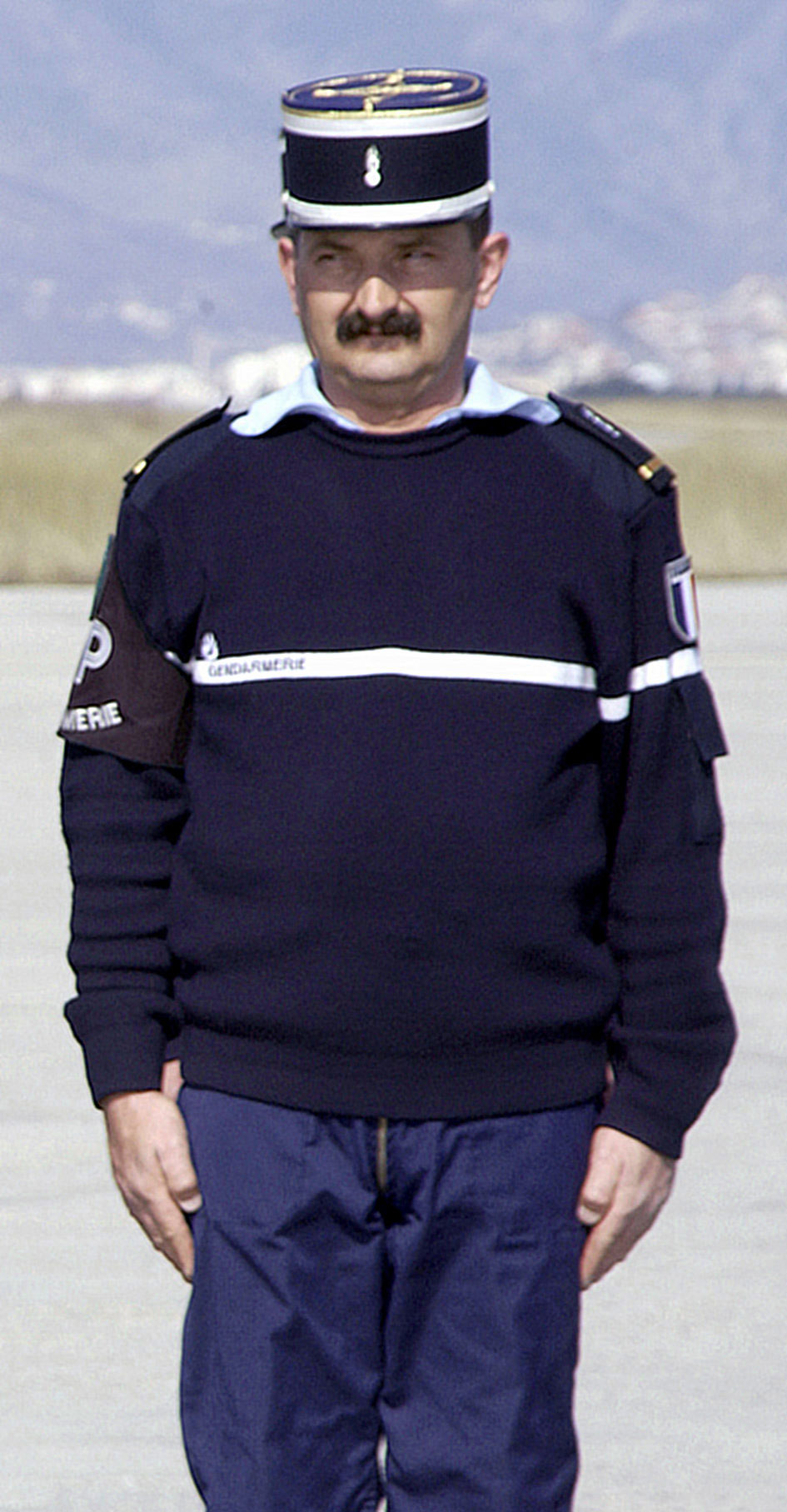 Esta imagen muestra a un hombre con un uniforme de policía de color azul.