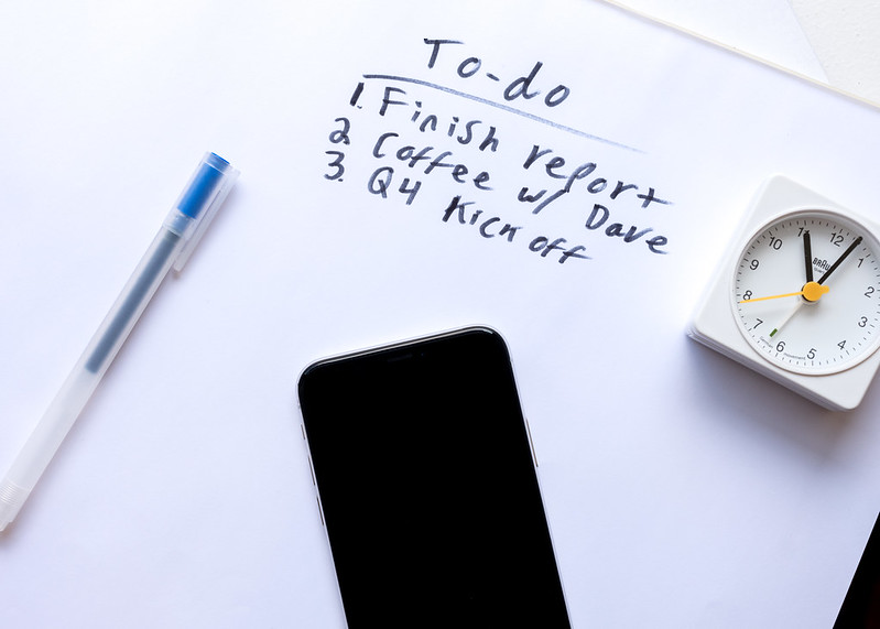 La imagen muestra un reloj, un móvil, un boli y anotaciones de tareas por hacer.