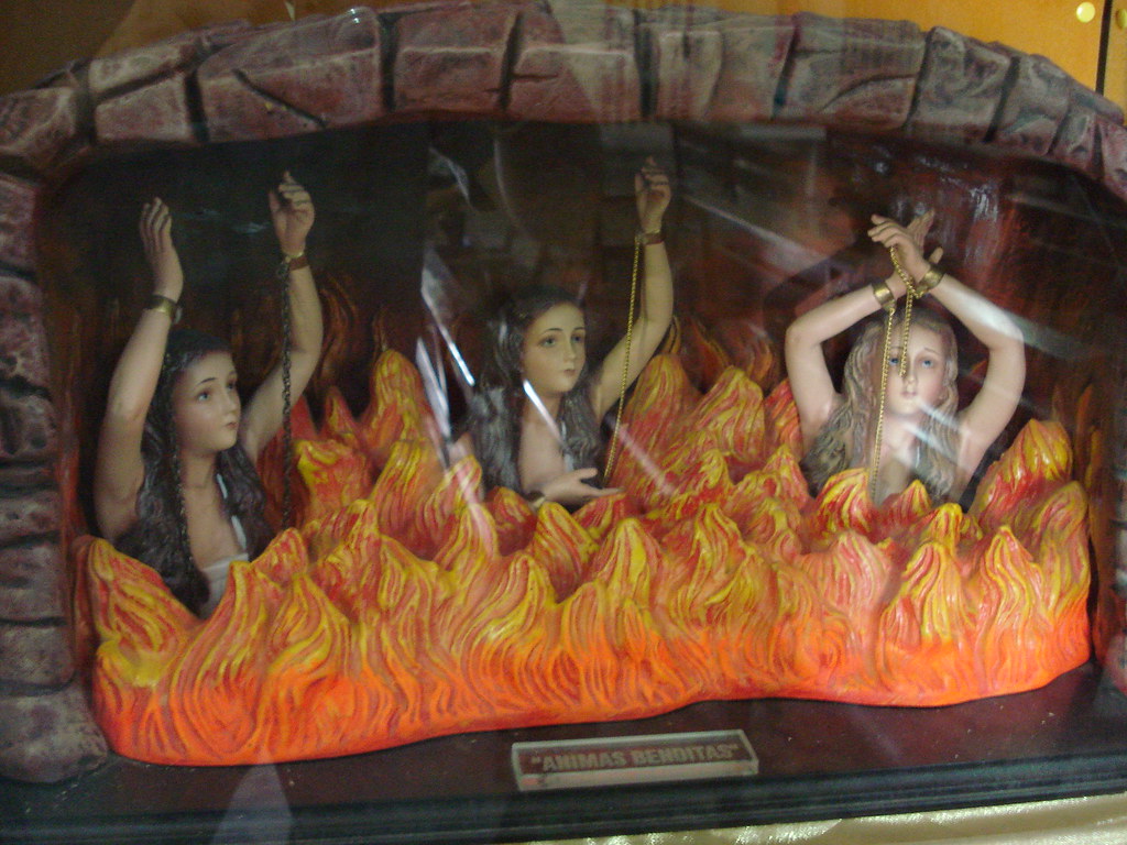 Esta imagen muestra una chimenea con fuego y del fuego salen tres mujeres con las manos encadenadas