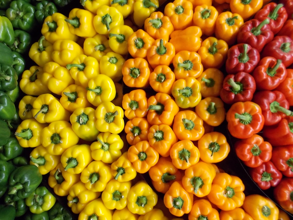 Esta imagen muestra pimientos de diversos colores, verdes, amarillos, naranjas y rojos.