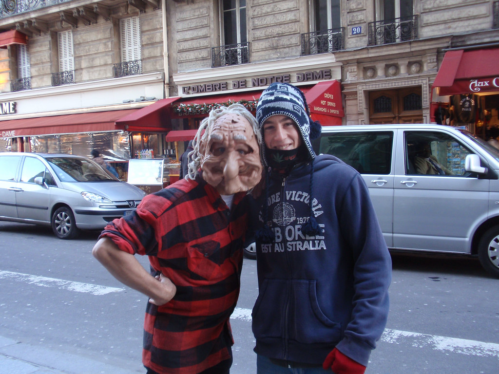 Esta imagen muestra a dos chicos y uno de ellos lleva una máscara puesta en la cabeza.